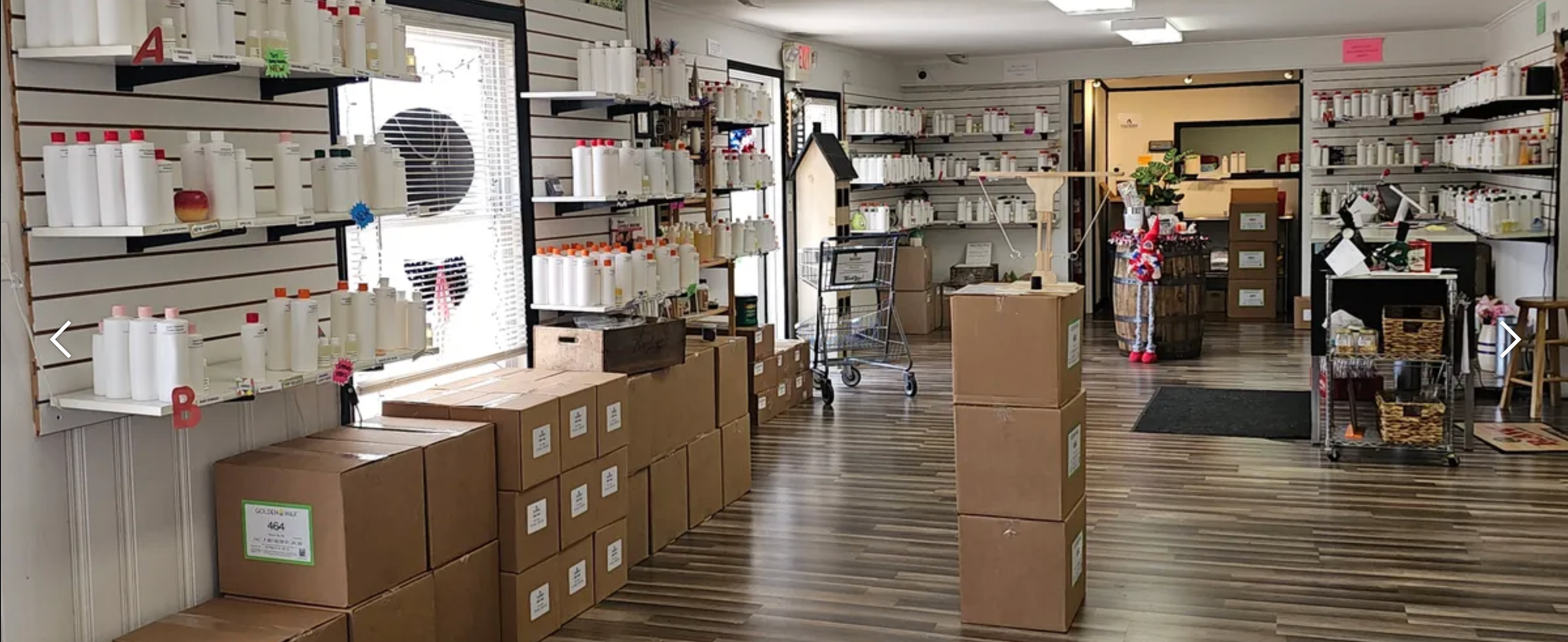 Store interior with shelves, fragrance oils, boxes, and products on a wooden floor.